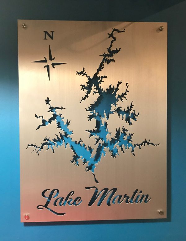 Lake Martin metal map with compass rose, mounted on a blue wall.