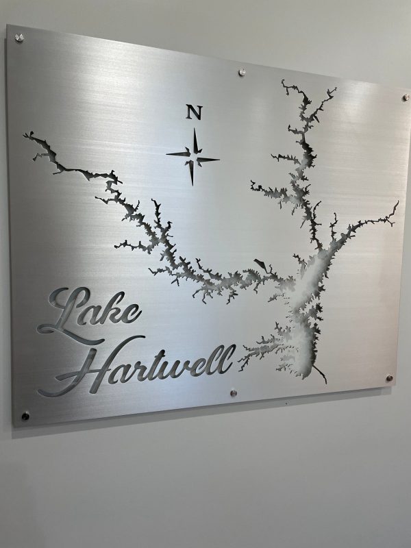 Lake Hartwell map cutout on brushed metal sign with decorative text and compass rose.