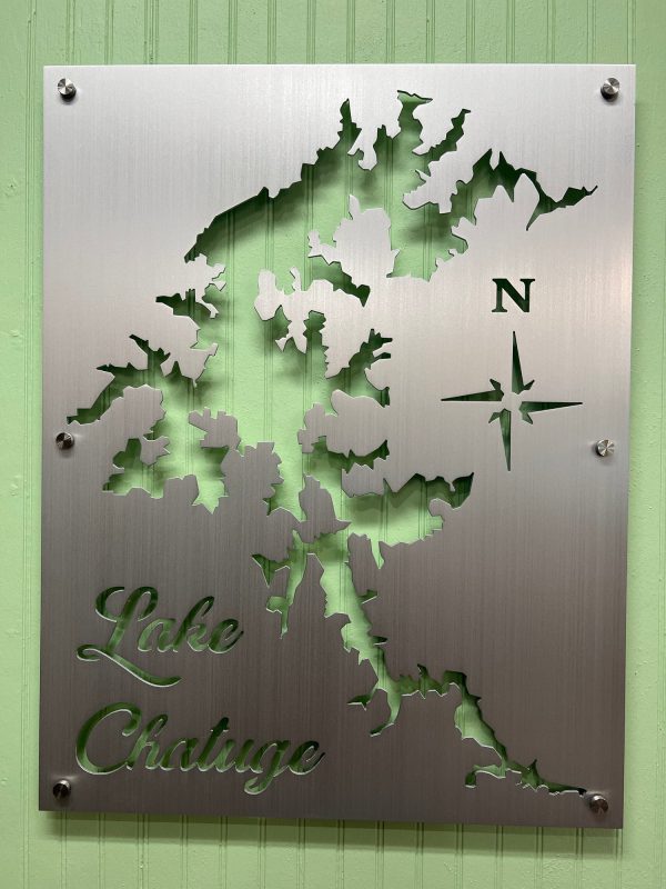 Lake Chatuge map cutout on brushed metal with compass rose, mounted on green wall.