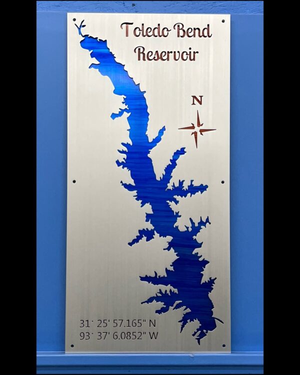 Toledo Bend Reservoir metal map with coordinates and compass rose, mounted on a blue wall.