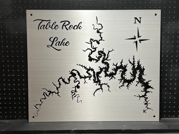 Table Rock Lake metal map with compass rose, featuring intricate cutout design on brushed silver, mounted on a pegboard.