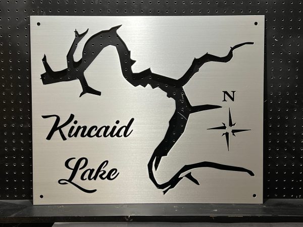 Kincaid Lake metal map with compass rose on brushed metallic background, mounted on a perforated black wall.