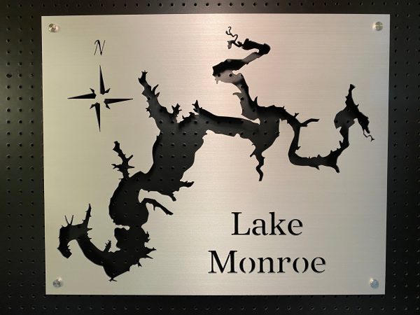 Lake Monroe metal cutout map with compass rose on a perforated black background.