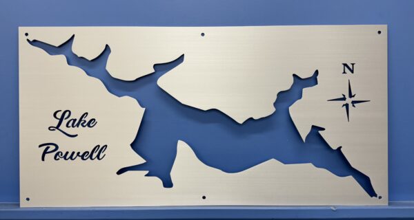 Lake Powell map cutout on metal, featuring a compass rose and decorative text, mounted on a blue wall.