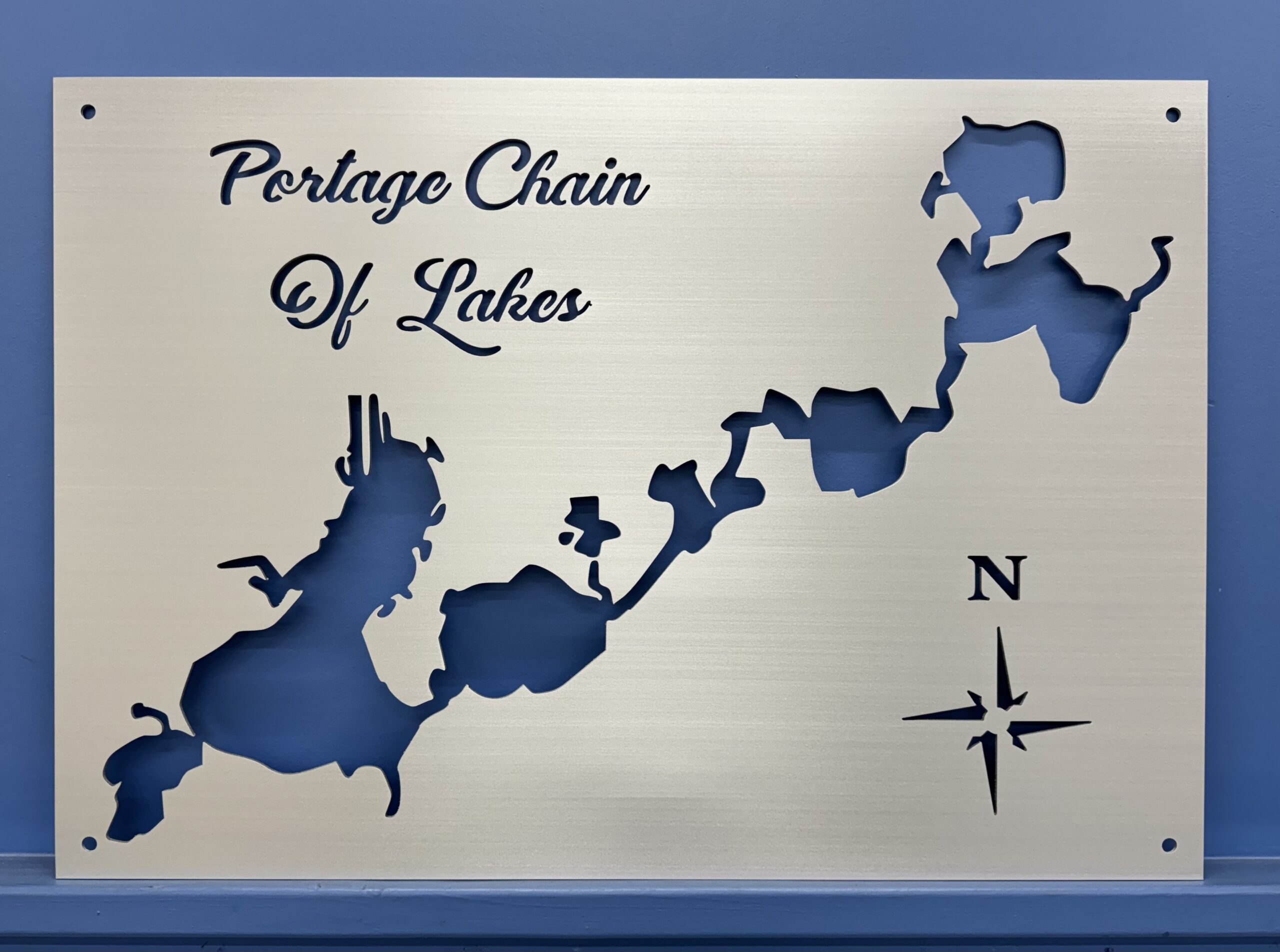 Brushed aluminum map of Portage Chain of Lakes with compass rose on blue background.